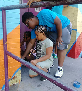 Students involved in Youthworks painting murals in Baltimore