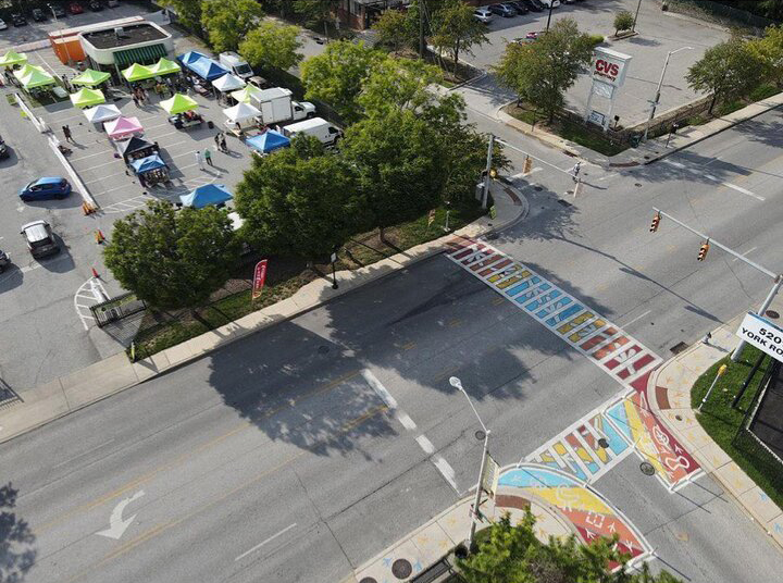 A sky view of the painted crosswalk and Govans Farmers Market on York Road