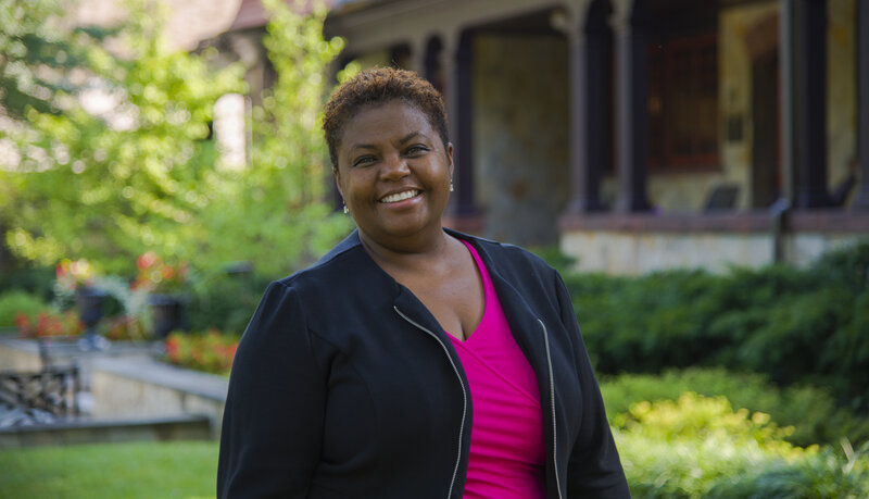 Cheryl Moore-Thomas, Ph.D., smiling while standing outside in front of the Humanities Center on Loyola's Evergreen campus