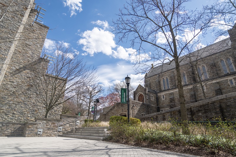 Blue sky is a backdrop for Alumni Memorial Chapel and the stone side of the Sellinger School building