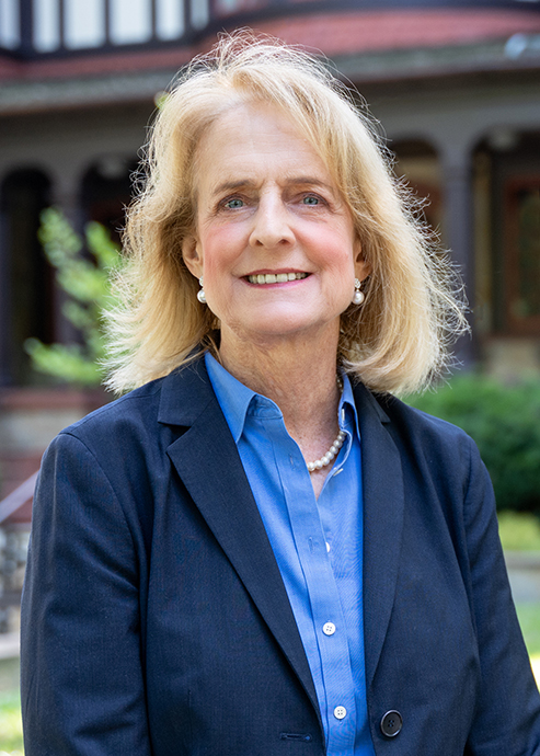 Dr. Sharon P. O'Neill smiling in front of the Humanities Center on Loyola's Evergreen Campus.