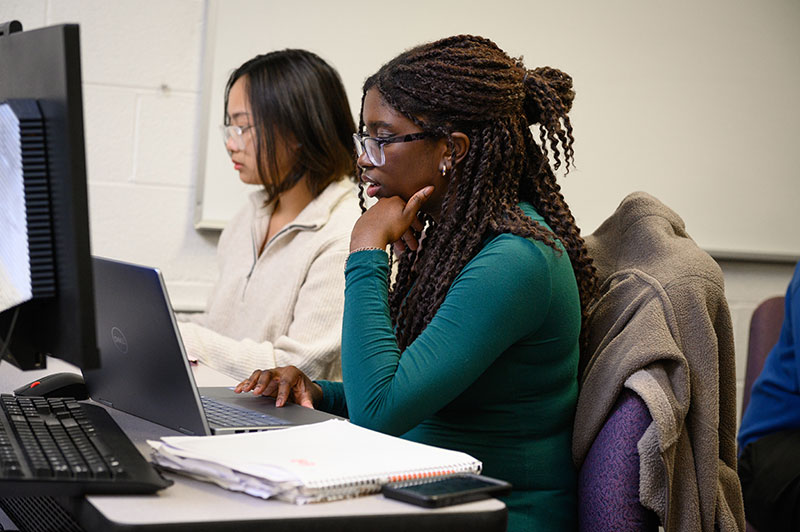 Two Loyola students work on their computers