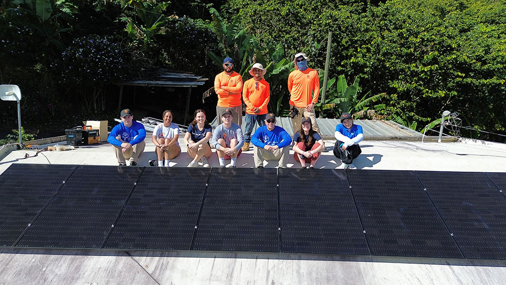 Loyola students install solar panels on a house in Adjuntas, Puerto Rico