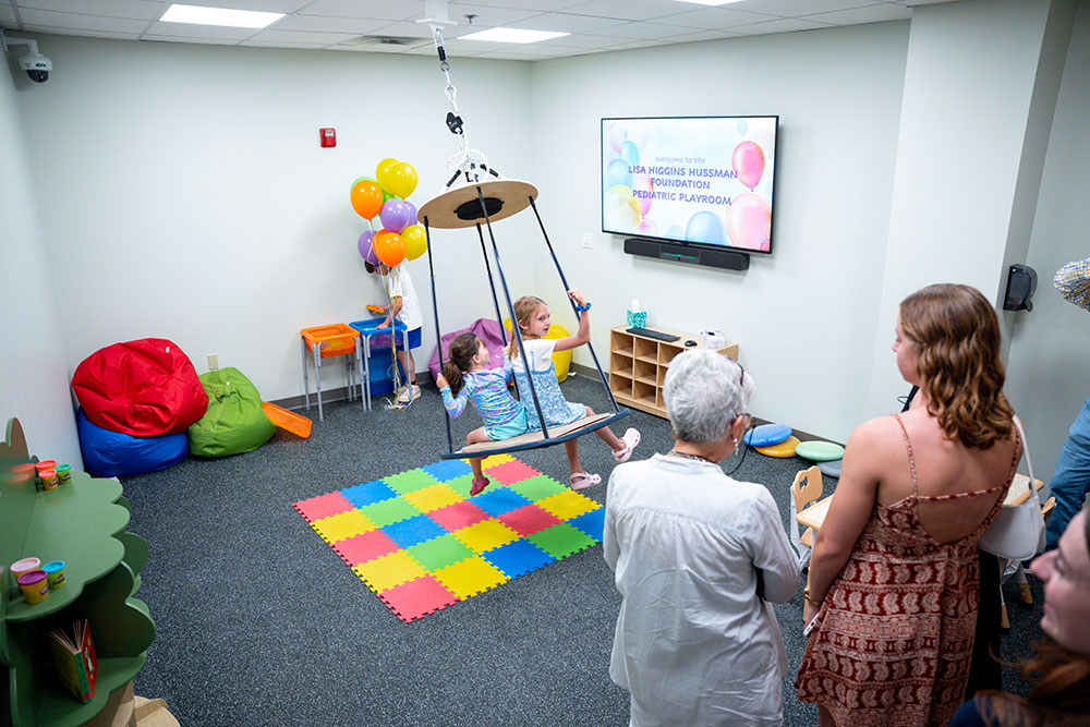 Children play on a swing at the grand opening of the Lisa Higgins Hussman Foundation Pediatric Playroom at the Loyola Clinical Centers on June 4, 2025 (Ryan Hiebler,
