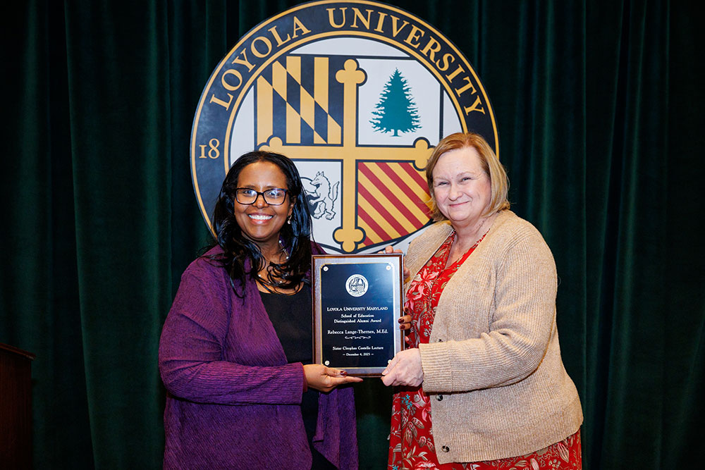 Afra Ahmed Hersi, Ph.D., dean of the School of Education, presents Rebecca Lange-Thernes, M.Ed. ’91, with the University’s School of Education Distinguished Alumni Award on Dec. 4, 2025 (Sid Keiser Photography)