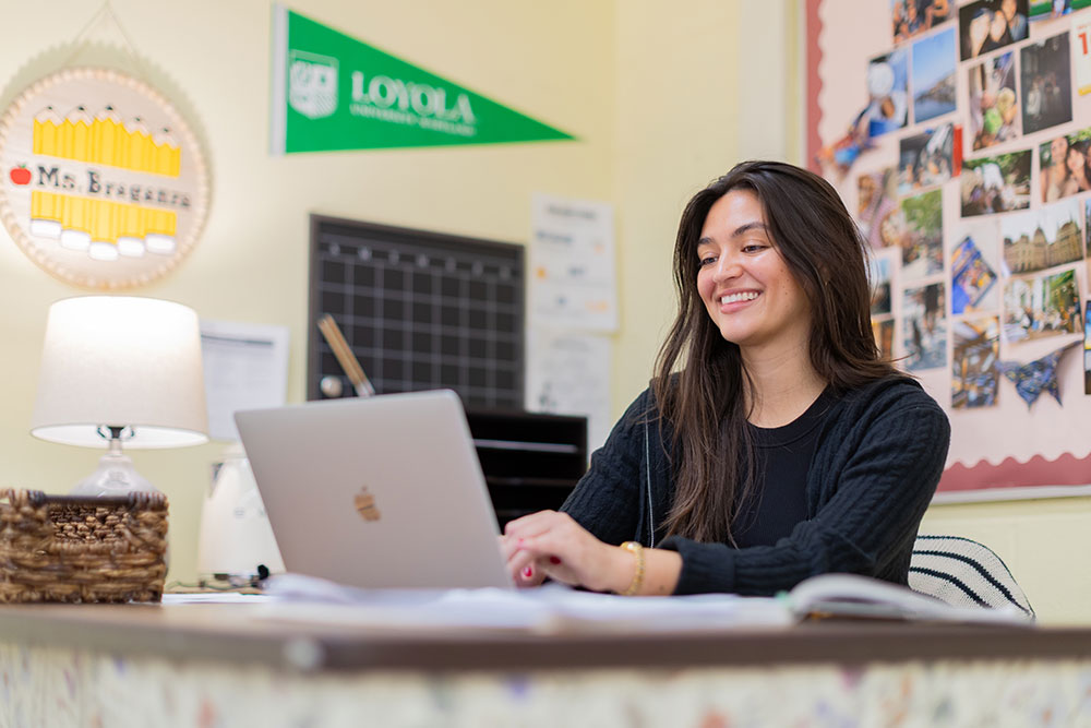 A Loyola School of Education student types on her laptop in a classroom at Roland Park Elementary/Middle School in Fall 2025