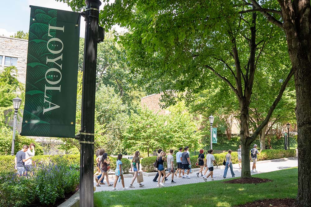 Loyola banner featured with students walking on campus in background