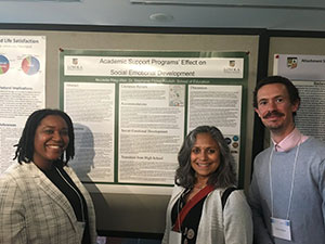 Stephanie Flores-Koulish standing with two students who presented at Emerging Scholars