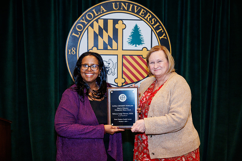Afra Ahmed Hersi, Ph.D., dean of the School of Education, presents Rebecca Lange-Thernes, M.Ed. ’91, with the University’s School of Education Distinguished Alumni Award on Dec. 4, 2025 (Sid Keiser Photography)