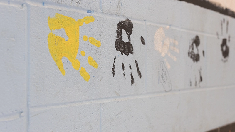 Students painted handprints line the wall of a local elementary school.